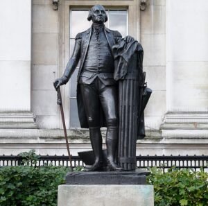 "Statue of George Washington standing in a dignified pose with a cane in one hand and a cloak draped over a Roman fasces, located outside the National Gallery in Trafalgar Square, London."