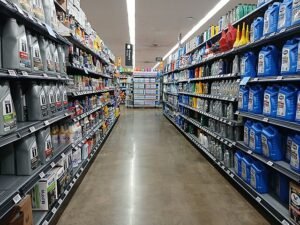 A well-stocked automotive aisle in a European Walmart store, showcasing a variety of motor oils and car maintenance products—highlighting the organized retail display and strong consumer demand in the auto parts sector.